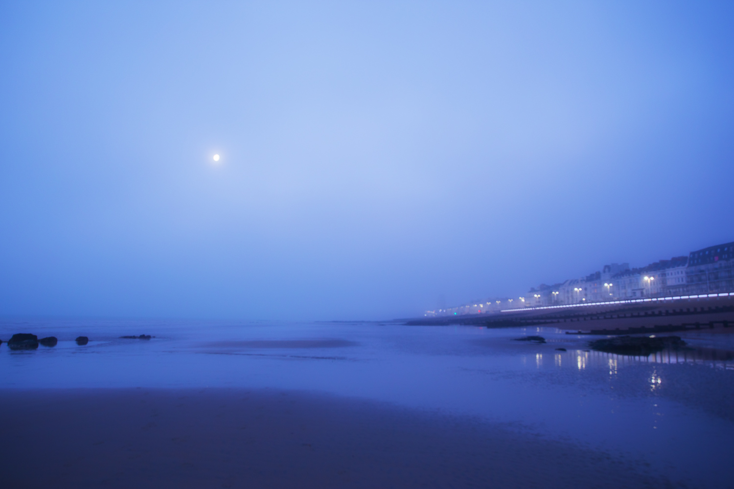 Seafront in mist and moonlight